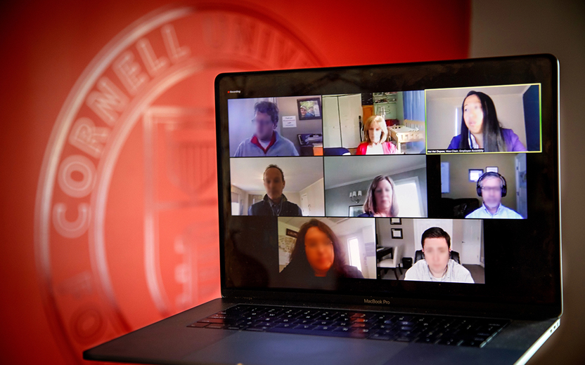 Laptop in front of the Cornell Logo. A video meeting is on the screen.