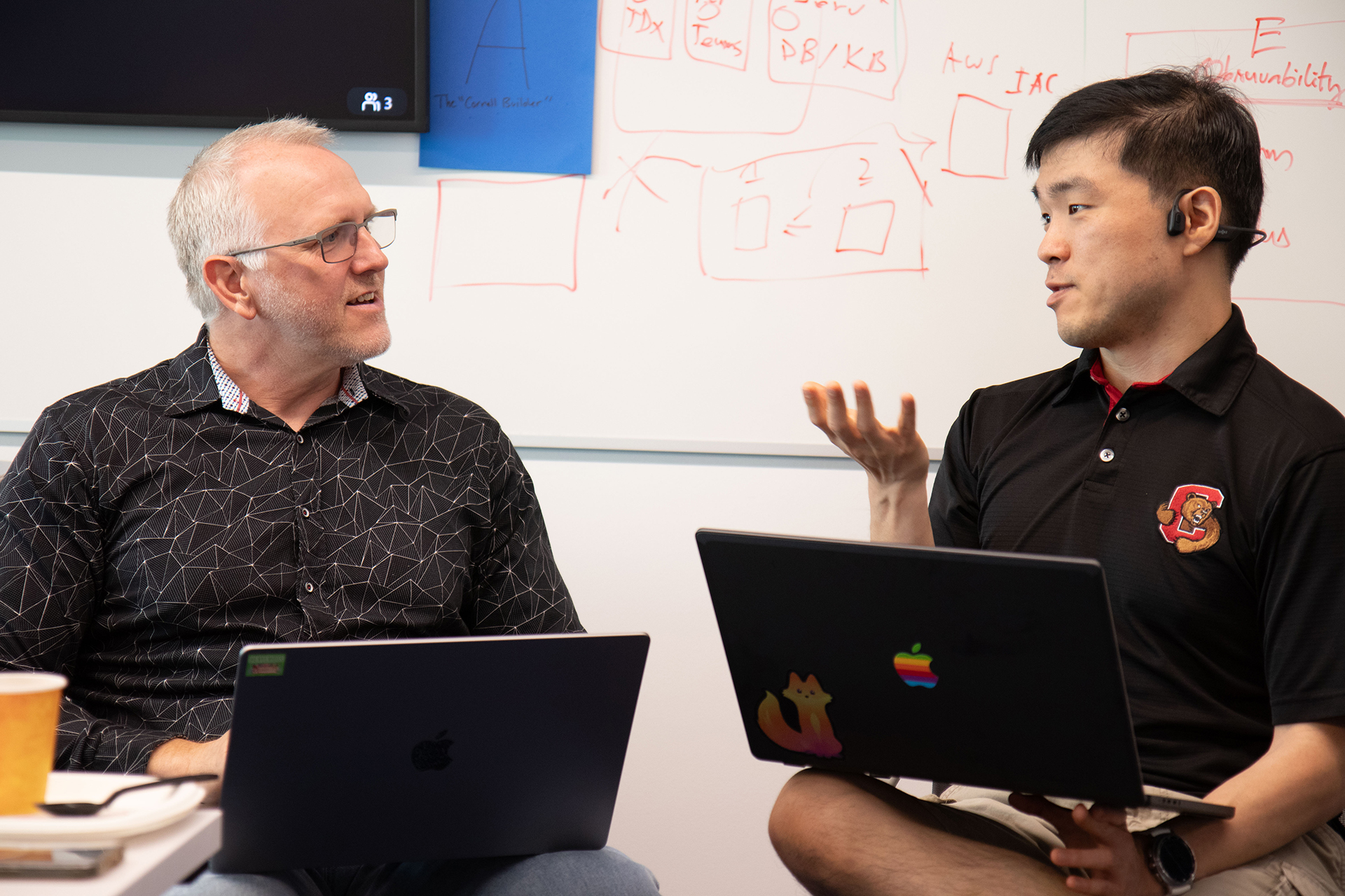 Two men discuss an opportunity to incorporate AI during a workshop breakout session.