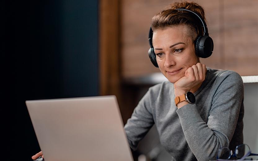 Person on a laptop listening with headphones