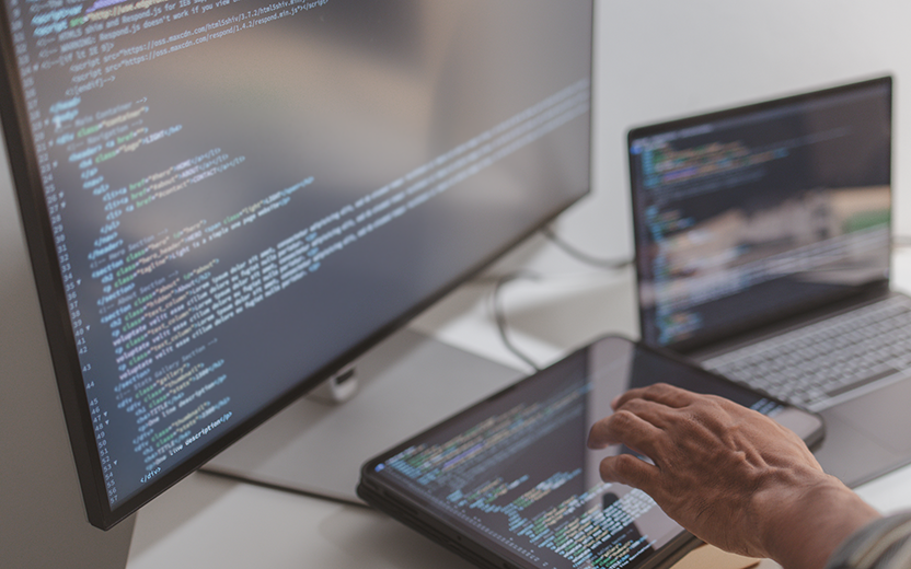 Person creating code on various computers