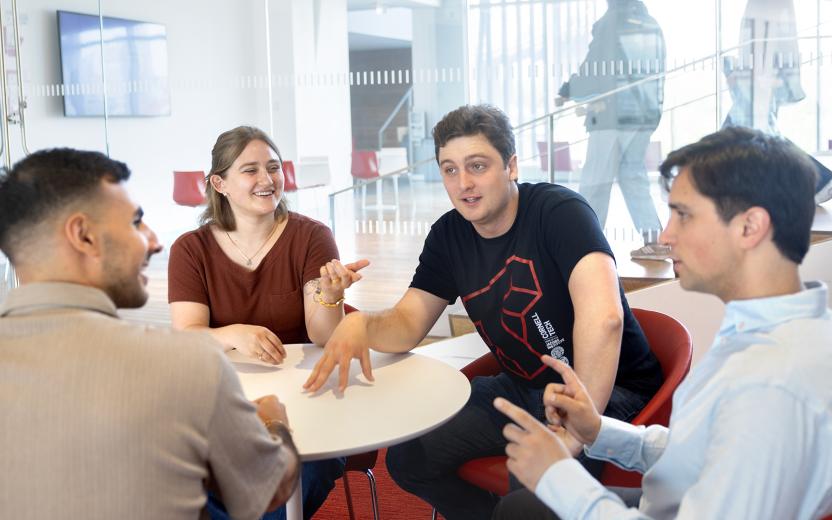 a group of colleagues discuss a project across a round table