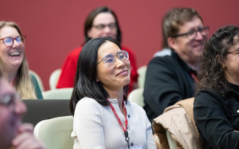 Smiling faces of an audience in a lecture hall