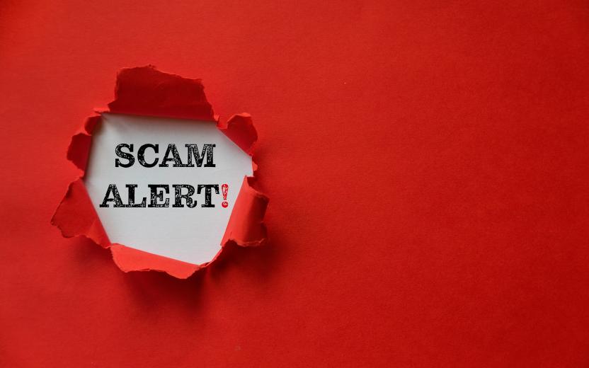 Red paper ripped open to reveal the words "scam alert!"