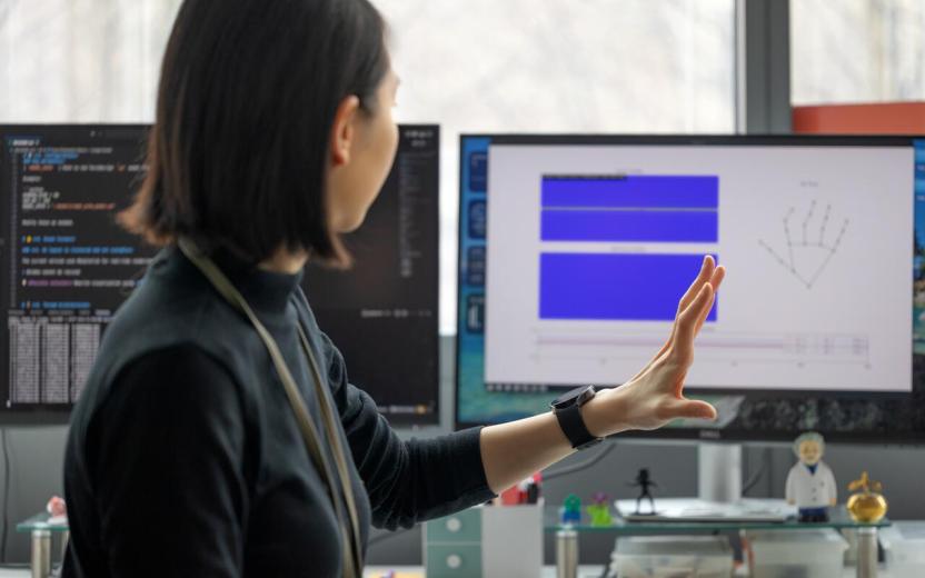 a doctoral student demonstrates updates on a display screen as her smart watch innovation records data