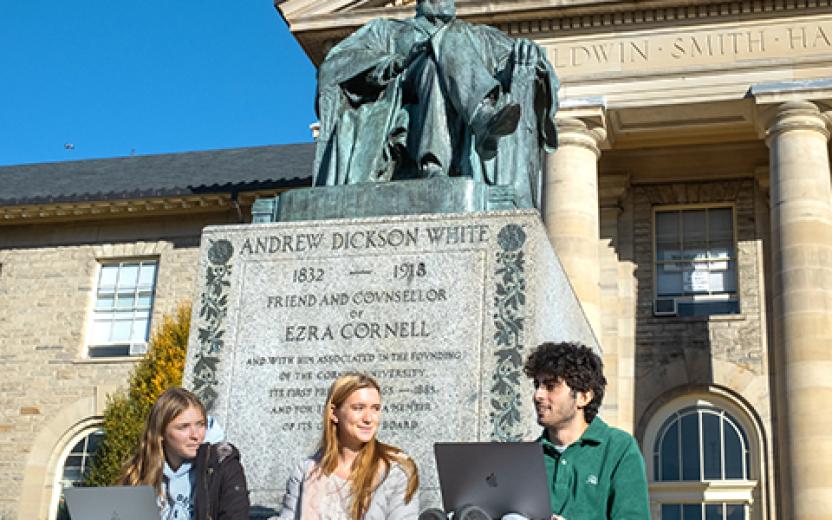 Students with computers in front of AD White statue