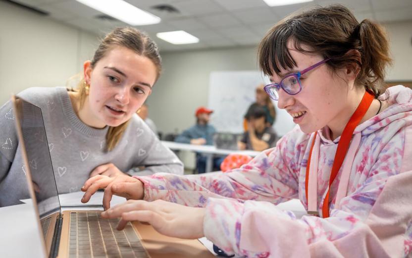 Two students explore web accessibility on a laptop at a table