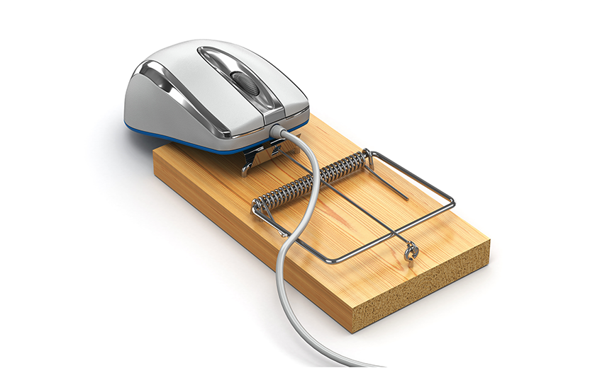 Computer mouse on top of a mousetrap