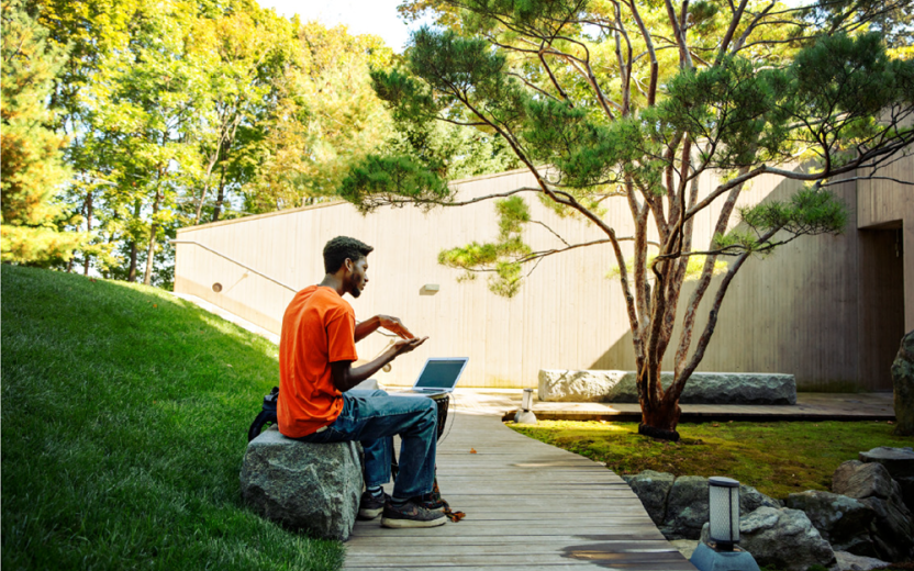 Student studying outdoors using a laptop