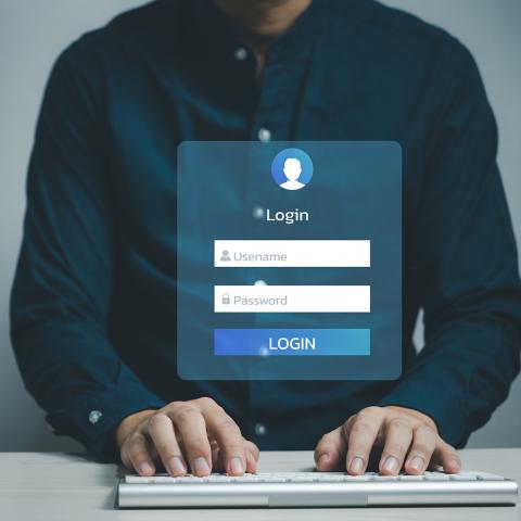 Person entering username and password into a login window.