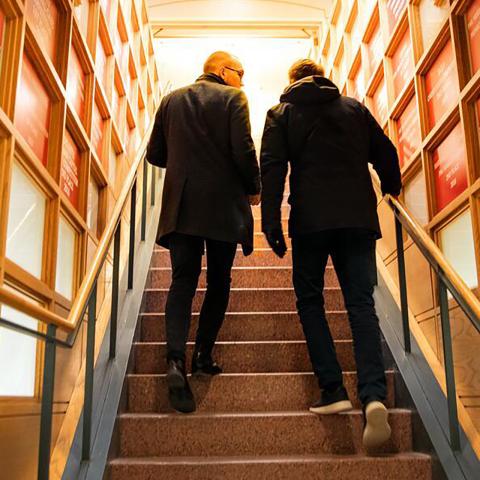 two people ascend stairs together as they talk