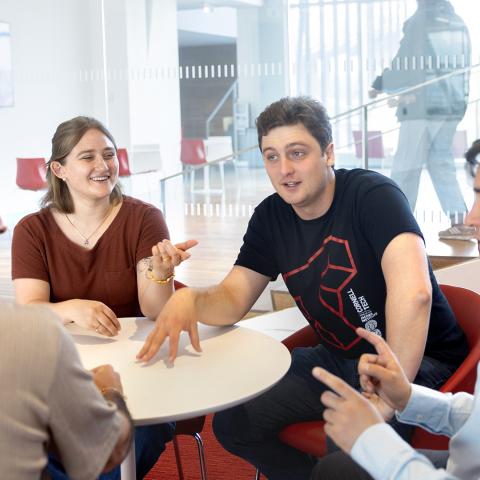 a group of colleagues discuss a project across a round table