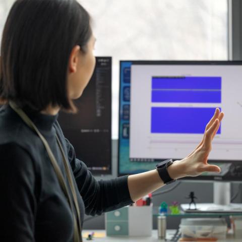 a doctoral student demonstrates updates on a display screen as her smart watch innovation records data