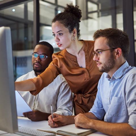 three people learning a new feature or skill at a large desktop display