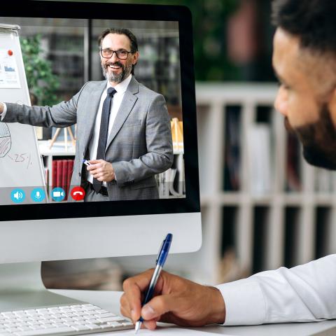 an office worker takes notes during a webinar
